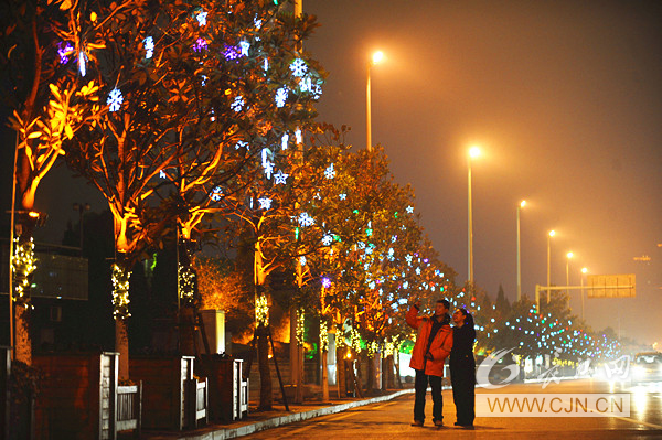 27日晚，在漢口沿江大道，兩位市民在景觀燈下合影。