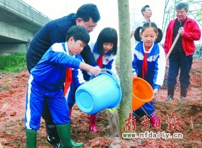 市委書記薛曉峰等與小學(xué)生一起植樹。