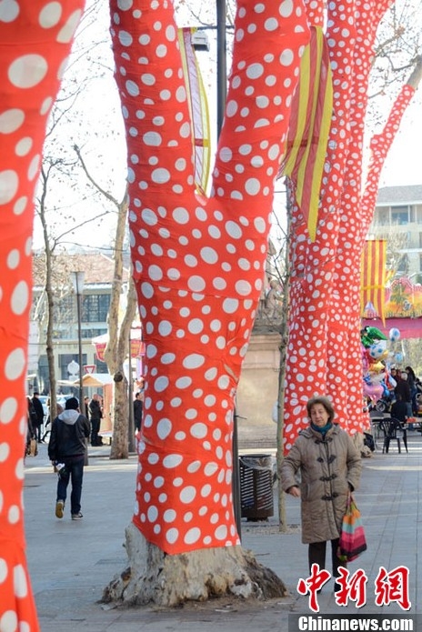 藝術(shù)家扮靚冬日街頭 為樹木穿上橙色圓點外衣