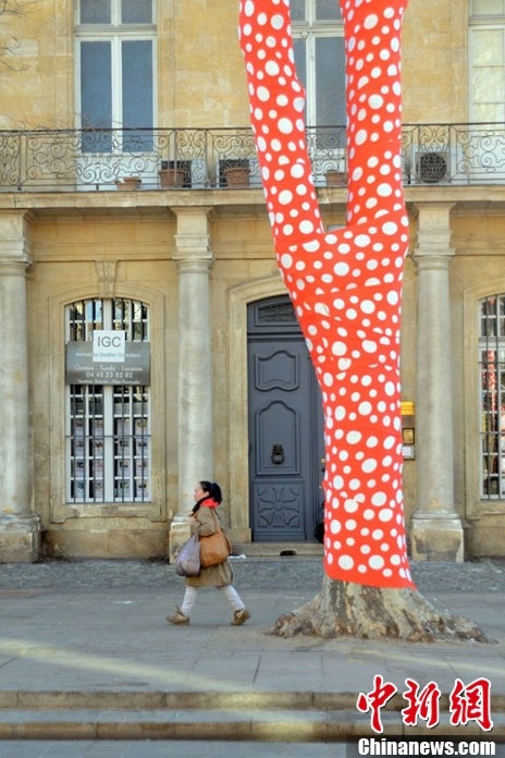 藝術(shù)家扮靚冬日街頭 為樹木穿上橙色圓點外衣